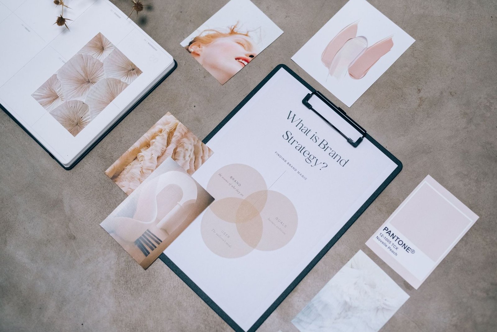 A brand mood board with a strategy sheet, photos and colour swatches laid out on a desk