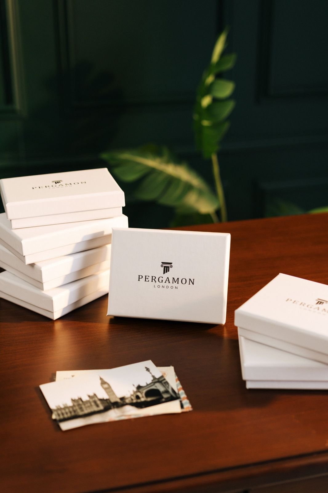 Stacks of white gift boxes printed with a simple black logo, ready to post