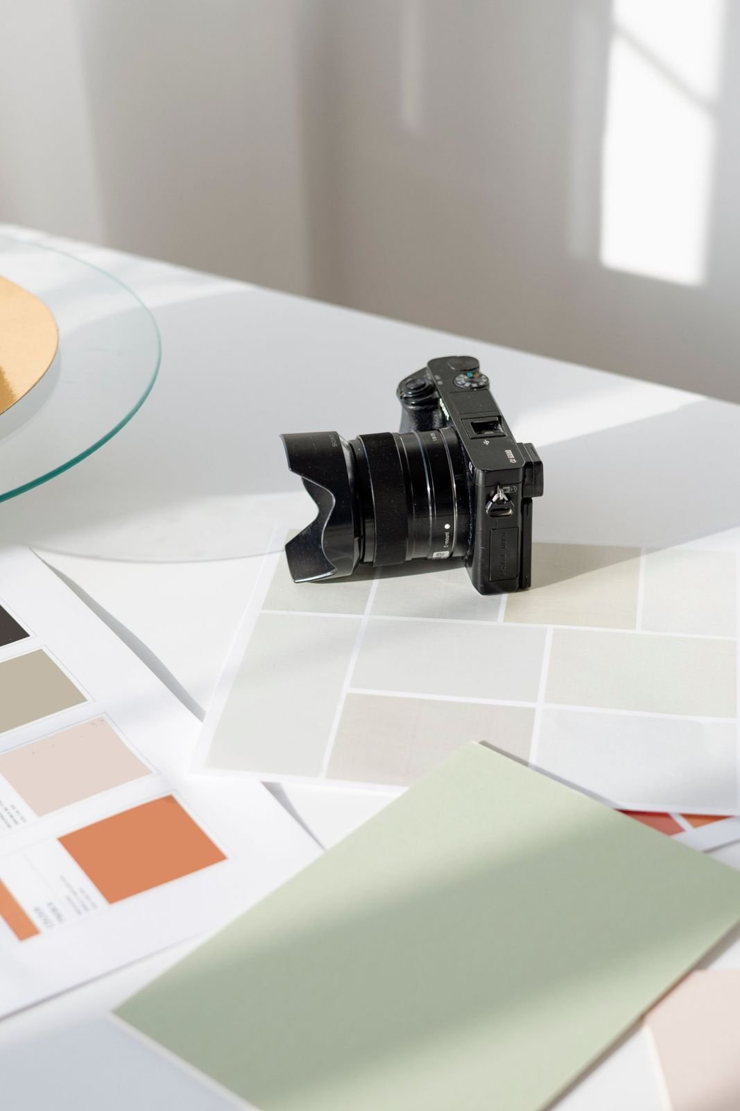 A camera resting on printed colour swatches in soft window light