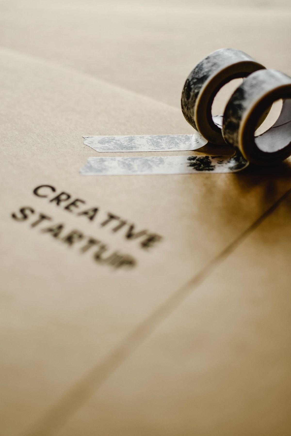A kraft paper box stamped with the words creative startup, sealed with patterned tape