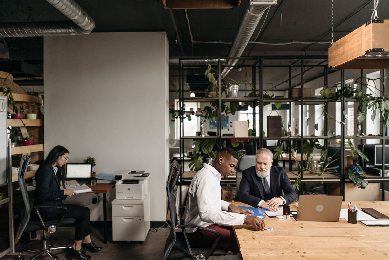 A small business team going through plans together around a laptop